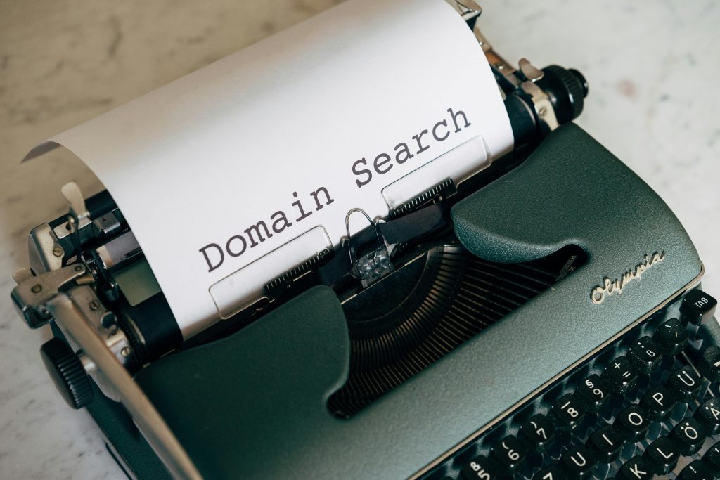 Close-up of a vintage typewriter with paper displaying 'Domain Search' text, ideal for retro themes.